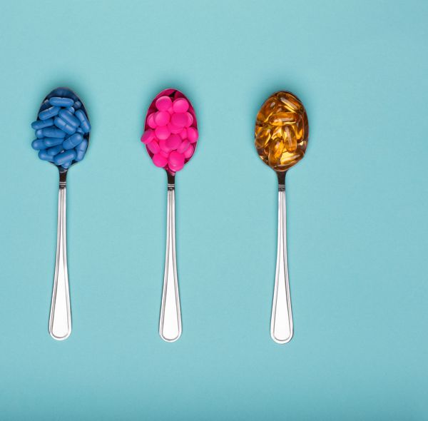 Three spoons with tablets on a blue background