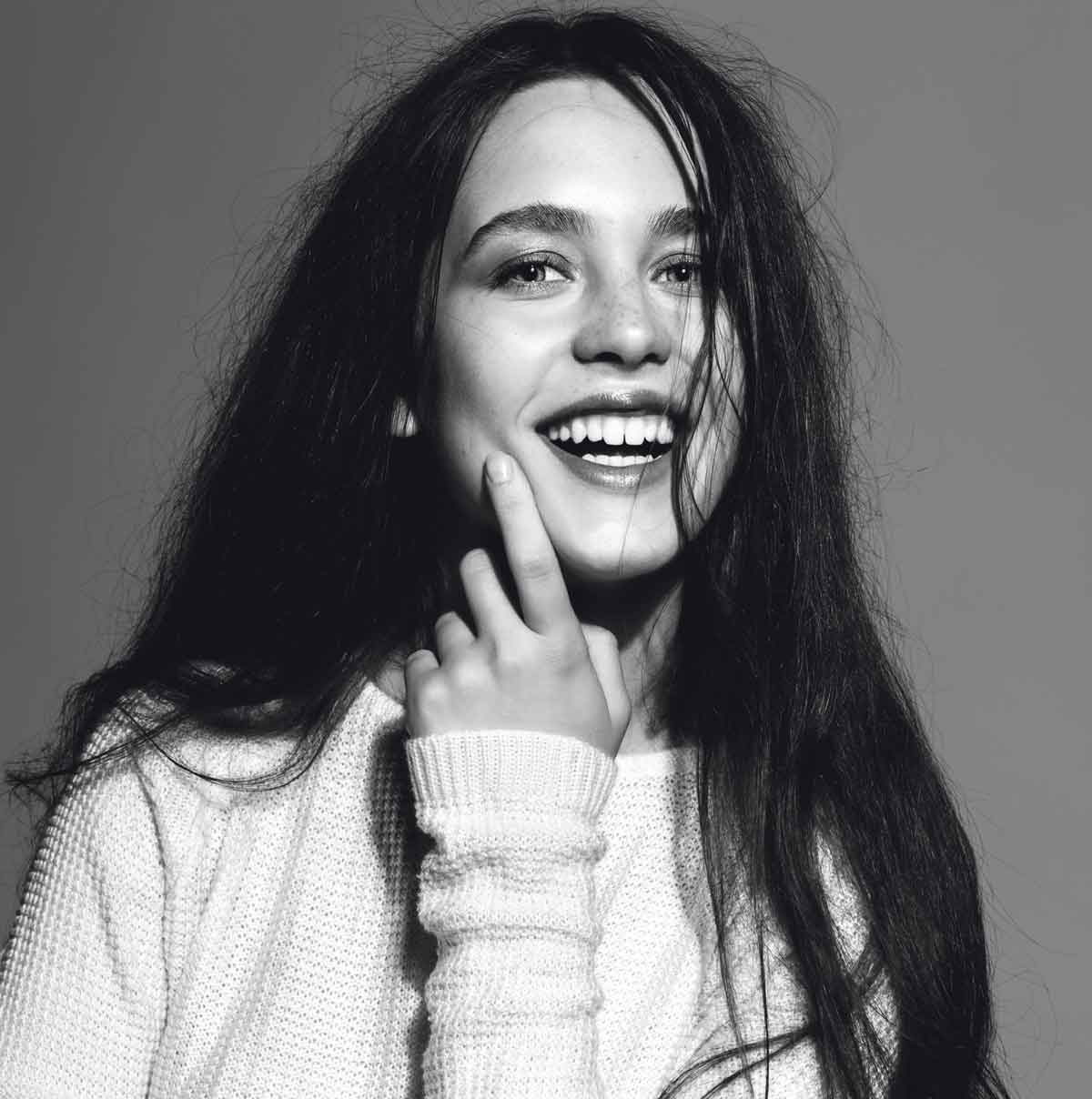 Black and white depiction of a woman with dark, long hair and a white jumper